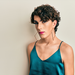 Junger Transgender-Man mit großen Ohrringen in Satin-Top.