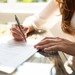 Junge Frau unterschreibt Arbeitsvertrag