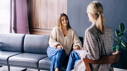 Lächelnde junge Frau im vertrauensvollen Gespräch mit ihrer Psychotherapeutin