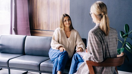 Lächelnde junge Frau im vertrauensvollen Gespräch mit ihrer Psychotherapeutin
