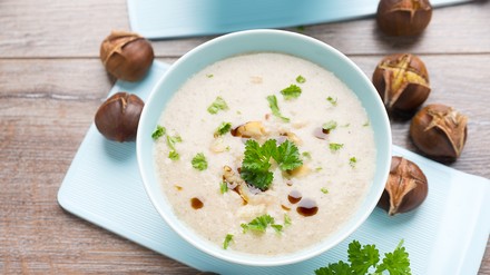 Kastaniensuppe in einer runden Schüssel, daneben Deko