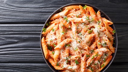 Ein Teller Pasta mit Tomatensauce und Käse.