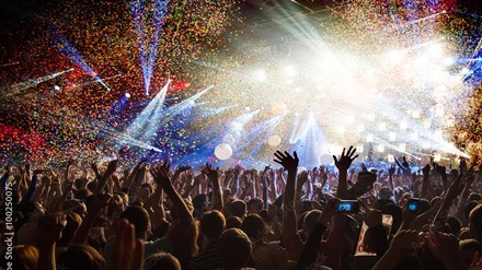 Menschen erleben ein Konzert und heben begeistert die Hände