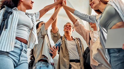 Eine Gruppe von Studienbeginnern geben sich High Five.
