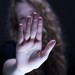 Frau streckt Hand abwehrend nach vorne.
