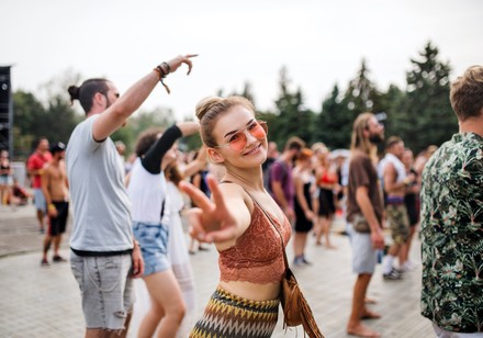 Eine Studentin feiert bei einem Open-Air-Festival vor einer Bühne.