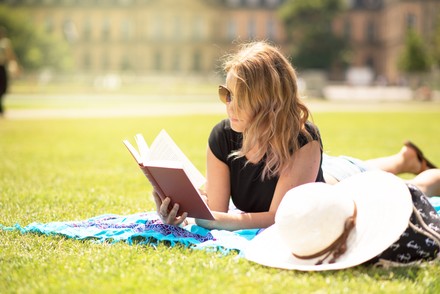 Studentin genießt einen schönen Sommertag und liest ein Buch.