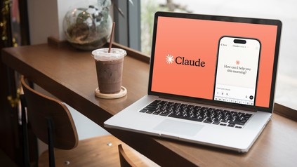 Ein geöffneter Laptop steht in einem Café, darauf ist die KI Claude geöffnet.