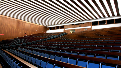 Leerer Hörsaal mit Stuhlreihen.