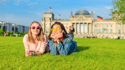 Zwei Studentinnen chillen vor dem Reichstag in Berlin.