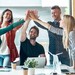 Junge Menschen am Arbeitsplatz geben sich ein High-Five