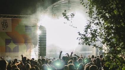 Das Festivalgelände am Augsburger Gaskessel mit Publikum bei abendlicher Stimmung.