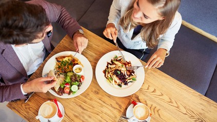 Zwei Studenten sitzen in einem Restaurant und essen zu Mittag.