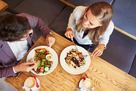 Zwei Studenten sitzen in einem Restaurant und essen zu Mittag.
