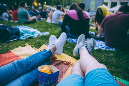 Das Publikum hat es sich vor der Leinwand auf der Wiese gemütlich gemacht.