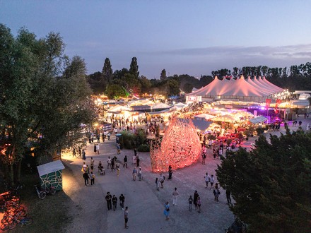 Luftaufnahme auf das abendliche, beleuchtete Festgelände.