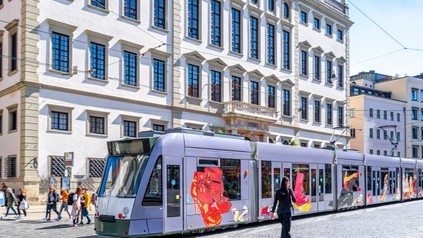 Eine Straßenbahn hält vor dem Augsburger Rathaus.