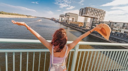 Blick auf den Rhein in Köln mit junger Frau im Vordergrund.