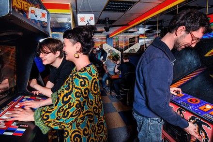 Eine Gruppe Museumsbesucher zockt in der Arcadehalle.