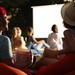 Studenten sehen sich im Open-Air-Kino einen Film an und essen Popcorn.