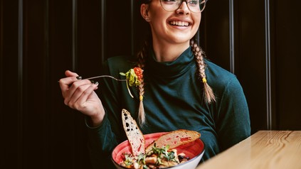 Studentin lässt sich in einem Restaurant eine köstliche Bowl schmecken.