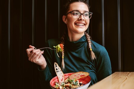 Studentin lässt sich in einem Restaurant eine köstliche Bowl schmecken.