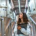 Studentin zwischen Biertanks in einer Brauerei.