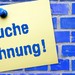 Blaue Kachelwand mit einem Schild in gelb mit den Worten: Suche Wohnung!