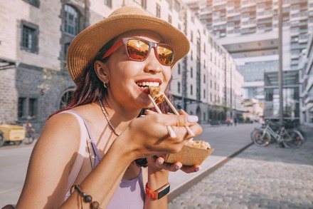 Eine Studentin lässt sich bei schönem Sommerwetter in der Kölner City einen Snack schmecken.