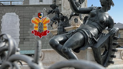 Der Augustusbrunnen, einer der Prachtbrunnen in Augsburg mit der Statue der Singold und im Hintergrund der Perlachturm geschmückt für das Turamichele.