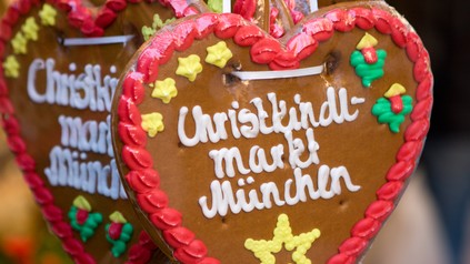 Lebkuchenherz mit der Aufschrift „Christkindl Markt München“ vor weiteren Weihnachtsmarkt-Lebkuchen.