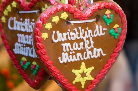Lebkuchenherz mit der Aufschrift „Christkindl Markt München“ vor weiteren Weihnachtsmarkt-Lebkuchen.