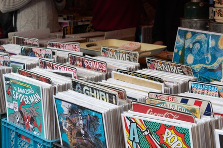 Flohmarktstand mit zahlreichen Comics und Manga-Heften, die in blauen Kunststoffkisten zum Stöbern angeboten werden.