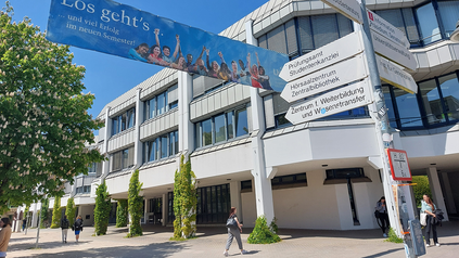 Campus der Uni Augsburg mit Willkommensbanner zum Semesterstart.