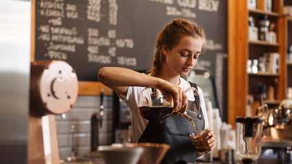 Junge Barista in einem Café bei der Zubereitung von Kaffee.