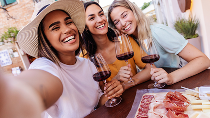 Junge Mädchen trinken Rotwein.