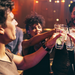 Fröhliche Freundesgruppe stößt im Club mit Getränken in den Händen an.