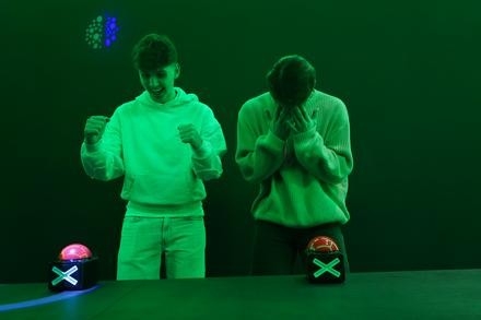 Zwei junge Männer beim Quiz Buzzer in der Duellbox.