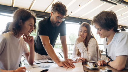 Junge Menschen diskutieren an einem Tisch.