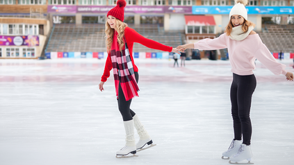 Zwei junge Frauen beim Eislaufen.