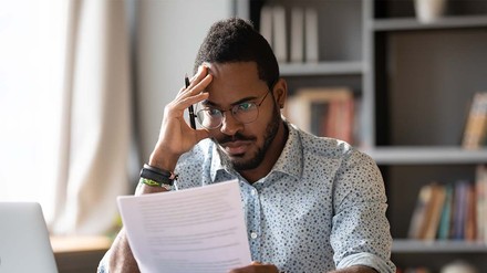 Auch für Studierende kann das Fehlen einer Haftpflichtversicherung unangenehm werden. (Foto: © stock.adobe.com/fizkes) verzweifelter Student an Schreibtisch
