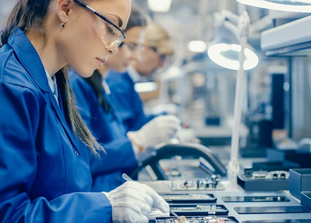 Junge frau arbeitet an Platine