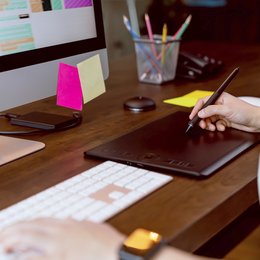 Frau nutzt Grafiktablett am Mac