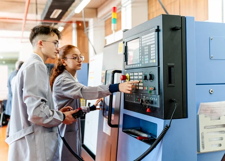 Zwei Studierende an einer CNC-Fräsmaschine