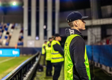 Junger Student als Sicherheitskraft in einem Fußballstadion