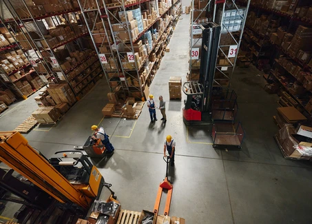 Hochregallager mit Mitarbeitern und Hubwagen