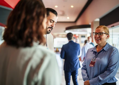 Drei Personen unterhalten sich auf einer Veranstaltung.