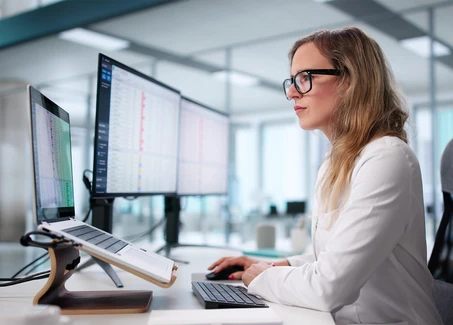 Blonde Frau im Büro am Computer