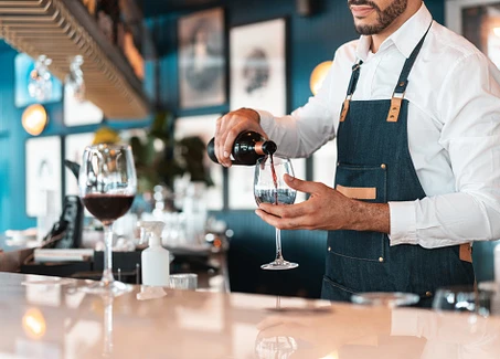 Barkellner schenkt Rotwein ein