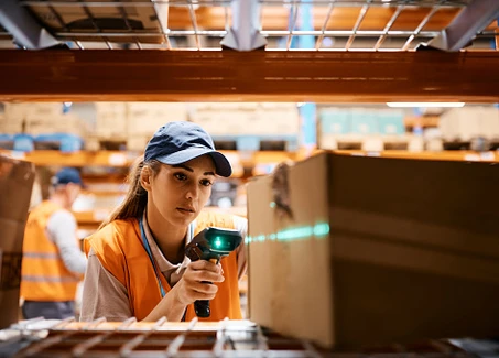 Junge Frau scannt Paket in Lager